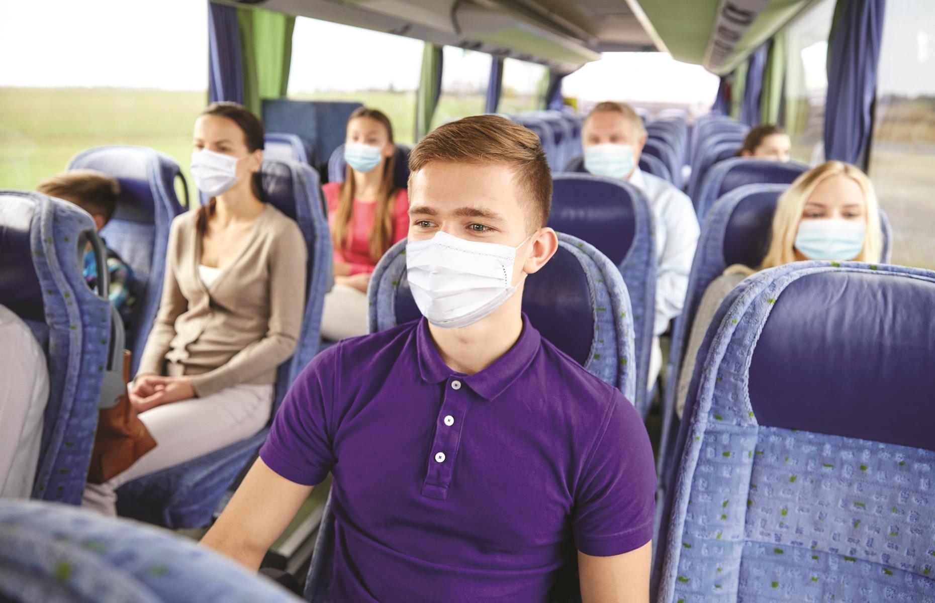 transport,tourism,roadtripandpeopleconcept youngmanwearingfaceprotectivemedicalmaskforprotectionfromvirusdiseasesittingintravelbusortrain