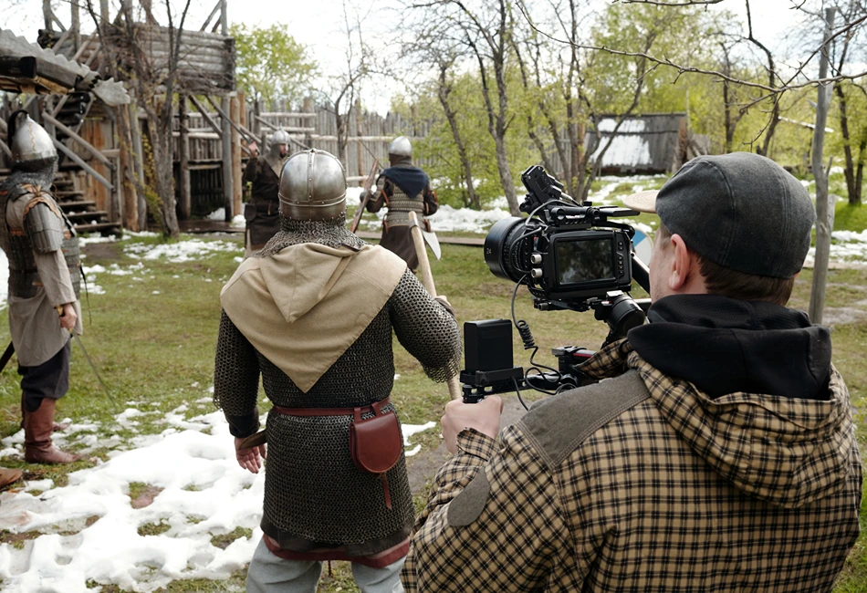 Film crew shooting a historical reenactment scene in a natural medieval setting. Photo credit Freepik
